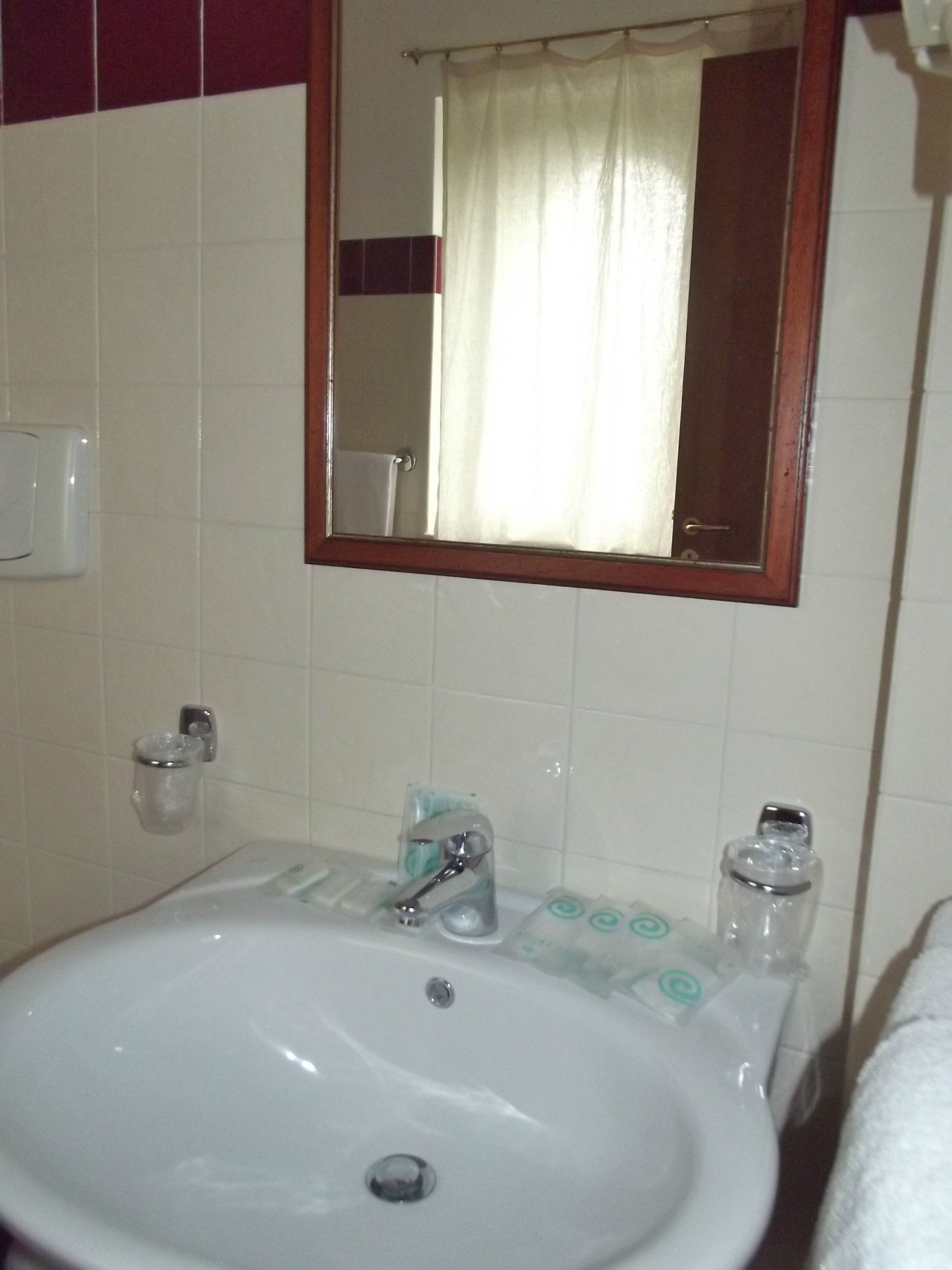 A bathroom with a white sink, a mirror, and a shower curtain.