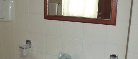 A bathroom with a white sink, a mirror, and a shower curtain.