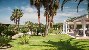 Un jardin bien entretenu, agrémenté de palmiers, d’un belvédère et d’espaces aménagés pour se détendre en plein air.