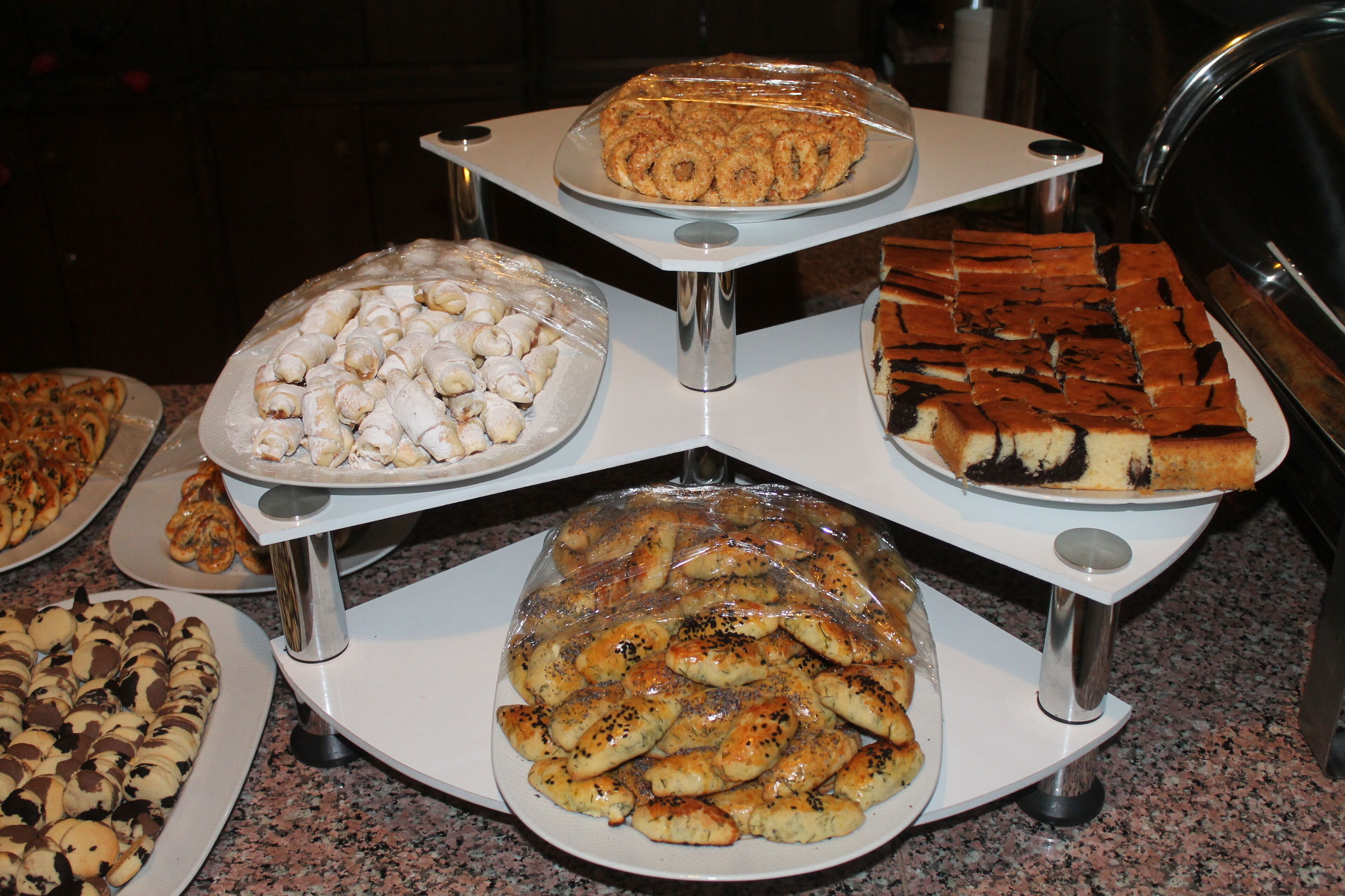 A buffet table with various dishes including pastries, bread, and desserts.