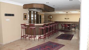 A bar area with high stools, a counter, and a mirror.