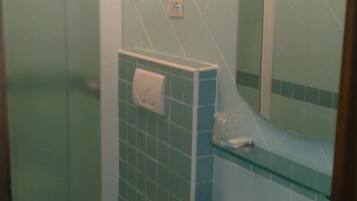 Une salle de bain avec des toilettes, un lavabo et un miroir.