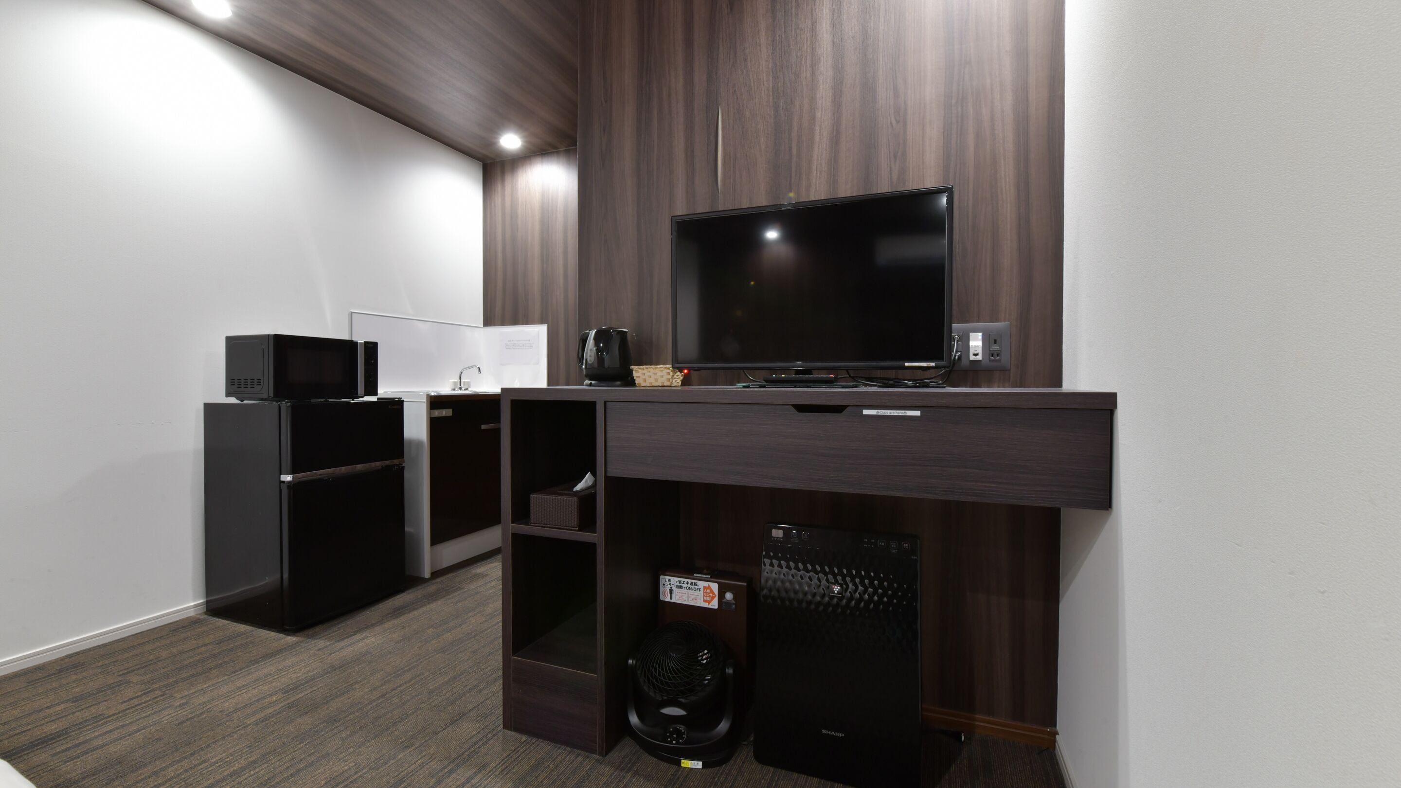 A compact kitchenette with a microwave, coffee maker, and a small refrigerator.