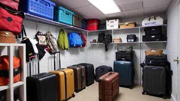 A storage room with various suitcases, bags, and boxes organized on shelves and the floor.