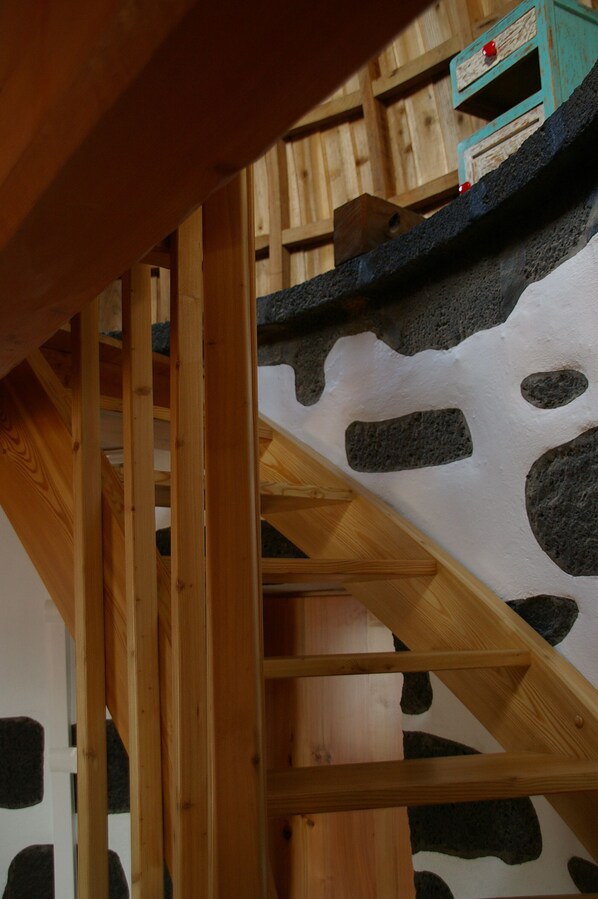 Un escalier en bois avec un mur en pierre.