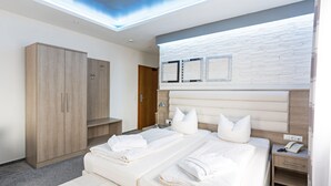 A modern hotel room with a large bed, a wardrobe, a bedside table with a phone, and a skylight above the bed. - Bavaria Hotel Superior (Stuttgart)