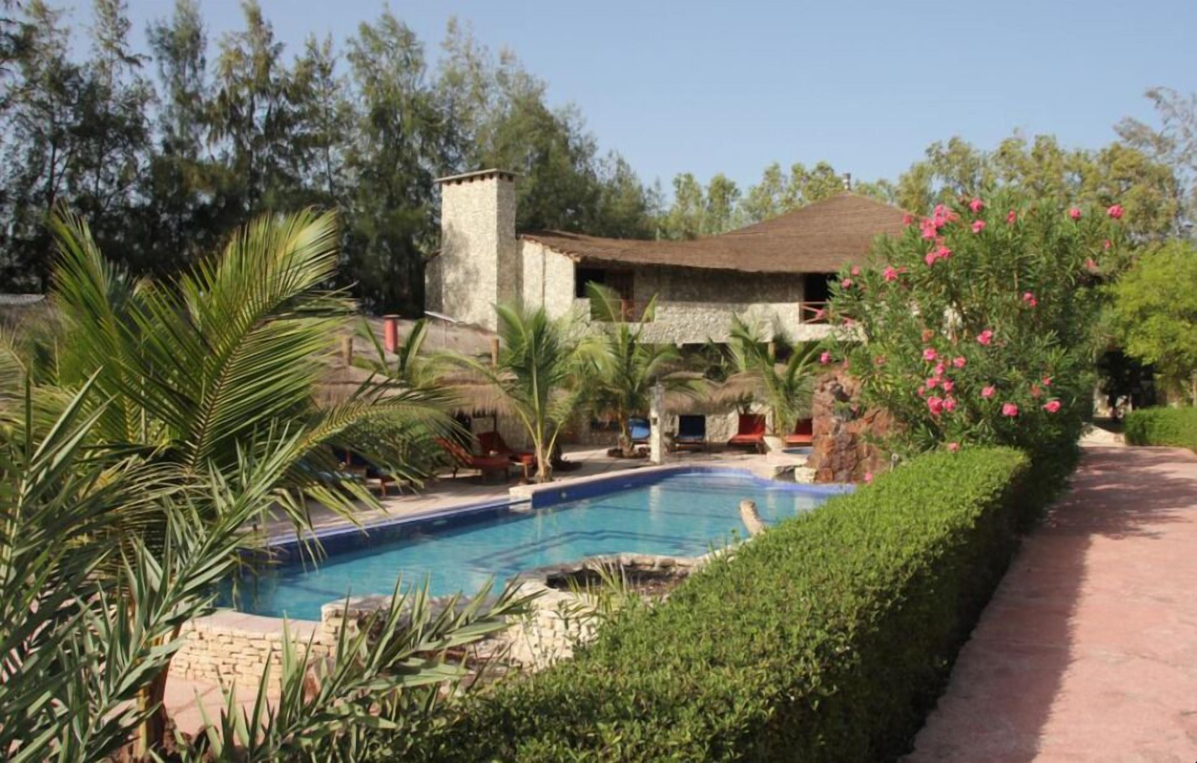 Een buitenzwembad, parasols bij het zwembad en ligstoelen