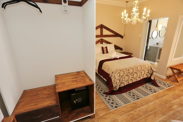 Un dormitorio con una cama, una mesita de noche de madera, una caja fuerte, un candelabro y una alfombra estampada.