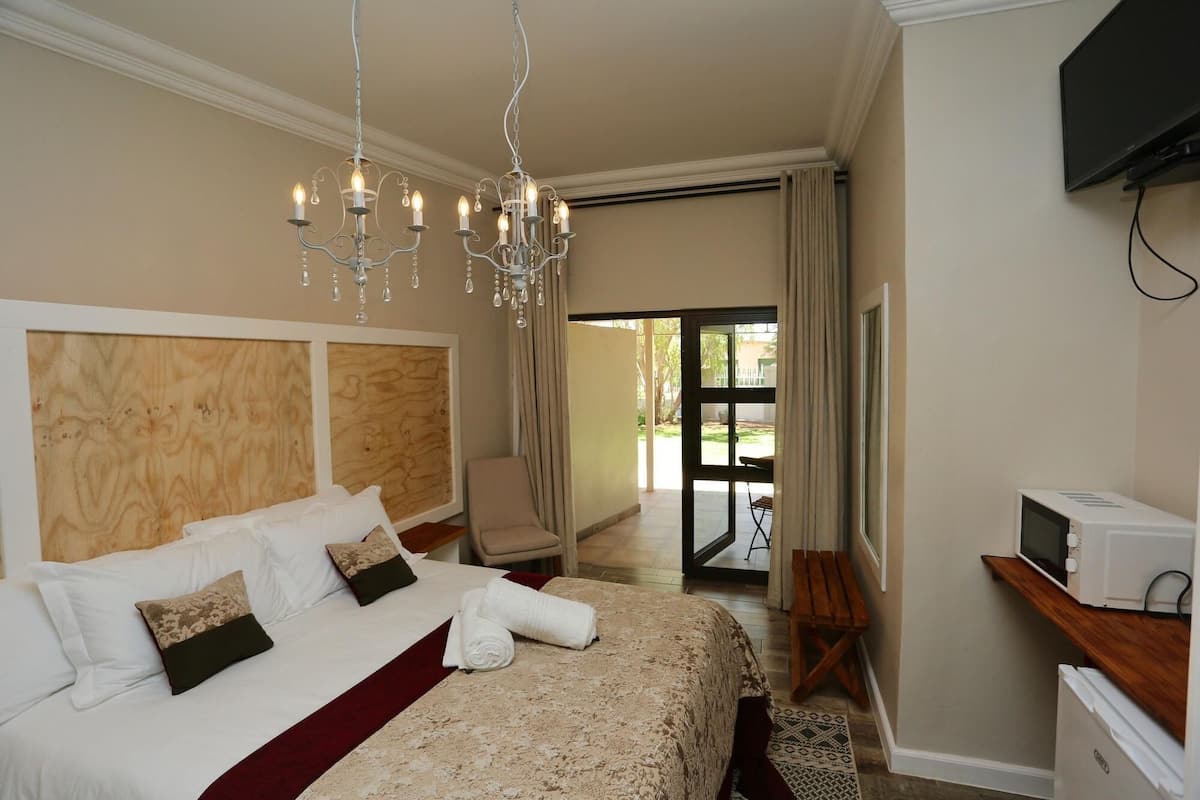 Une chambre d’hôtel avec un lit, une chaise, un téléviseur et une vue sur l’extérieur.