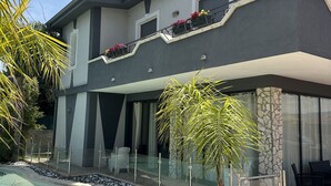 A modern two-story house with a swimming pool, stone walls, and a balcony with flower boxes. - Villa Joel with splendid swimming pool in the heart of Fontane Bianche (Fontane Bianche)