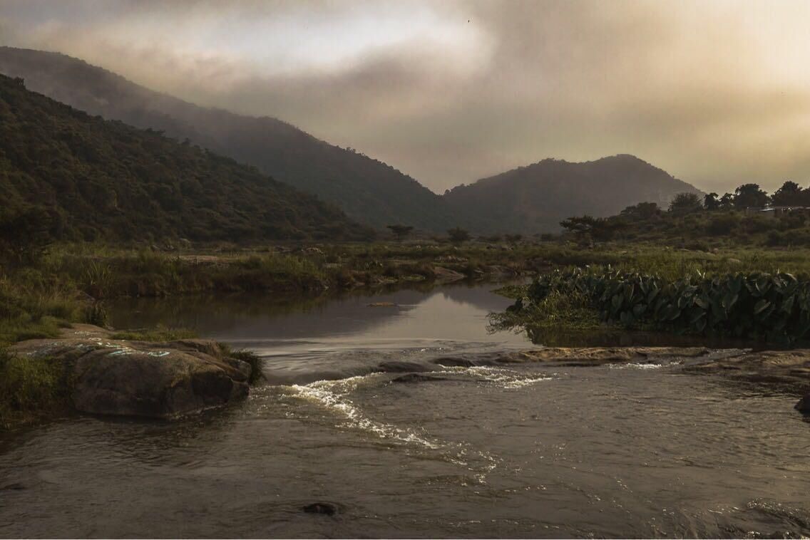 Un río que serpentea por un valle, con montañas al fondo.