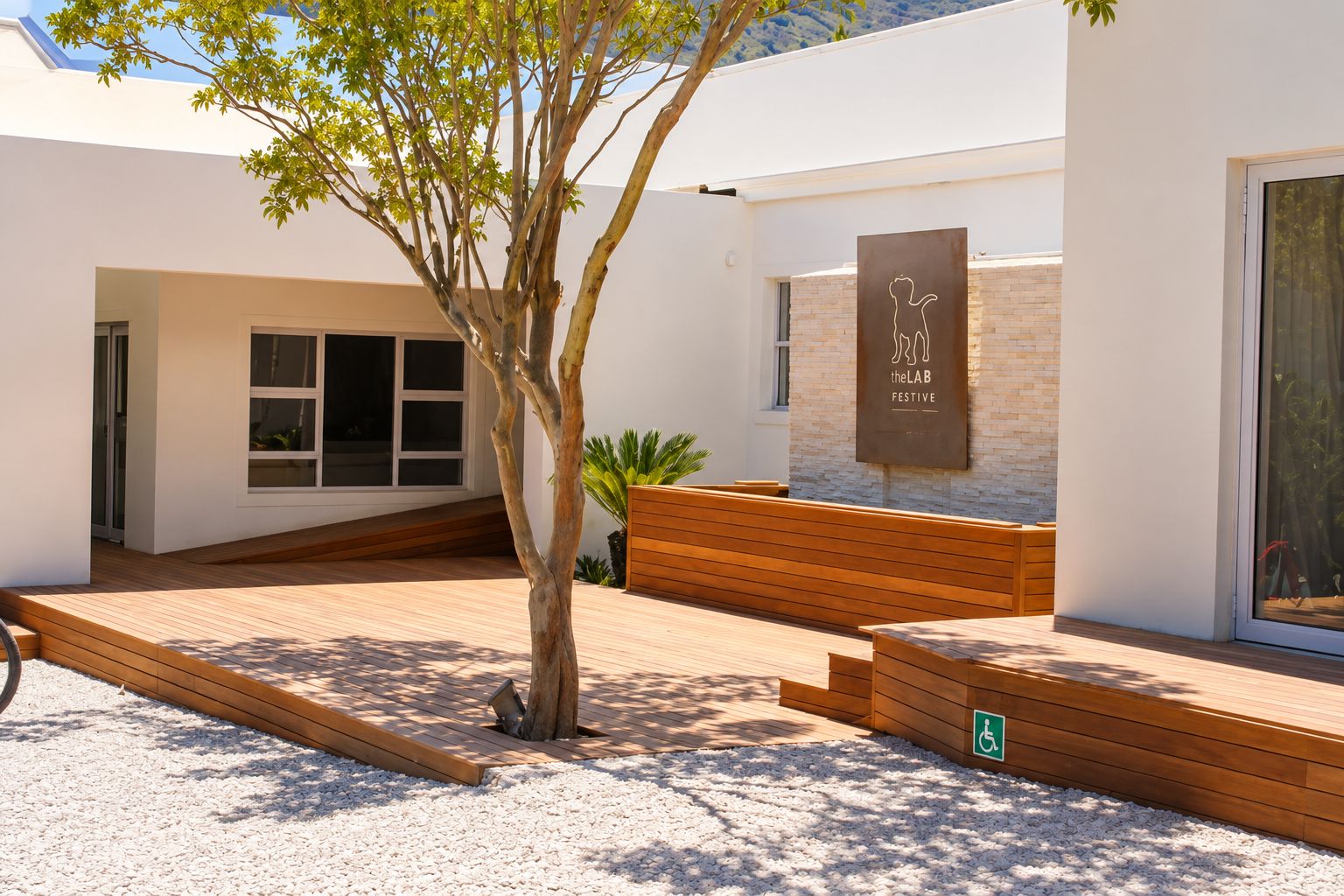 A modern building with a wooden deck, a tree, and a sign that reads 'theLAB FESTIVE'.