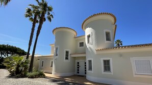 A two-story building with a curved facade, multiple windows, and a tiled roof. - 4 Bedroom Deluxe Villa, Private Pool, Mature Grounds, Hot Tub*, Putting Green + (Quarteira)