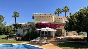 A two-story house with a swimming pool, outdoor seating, and lush landscaping. - 4 Bedroom Deluxe Villa, Private Pool, Mature Grounds, Hot Tub*, Putting Green + (Quarteira)
