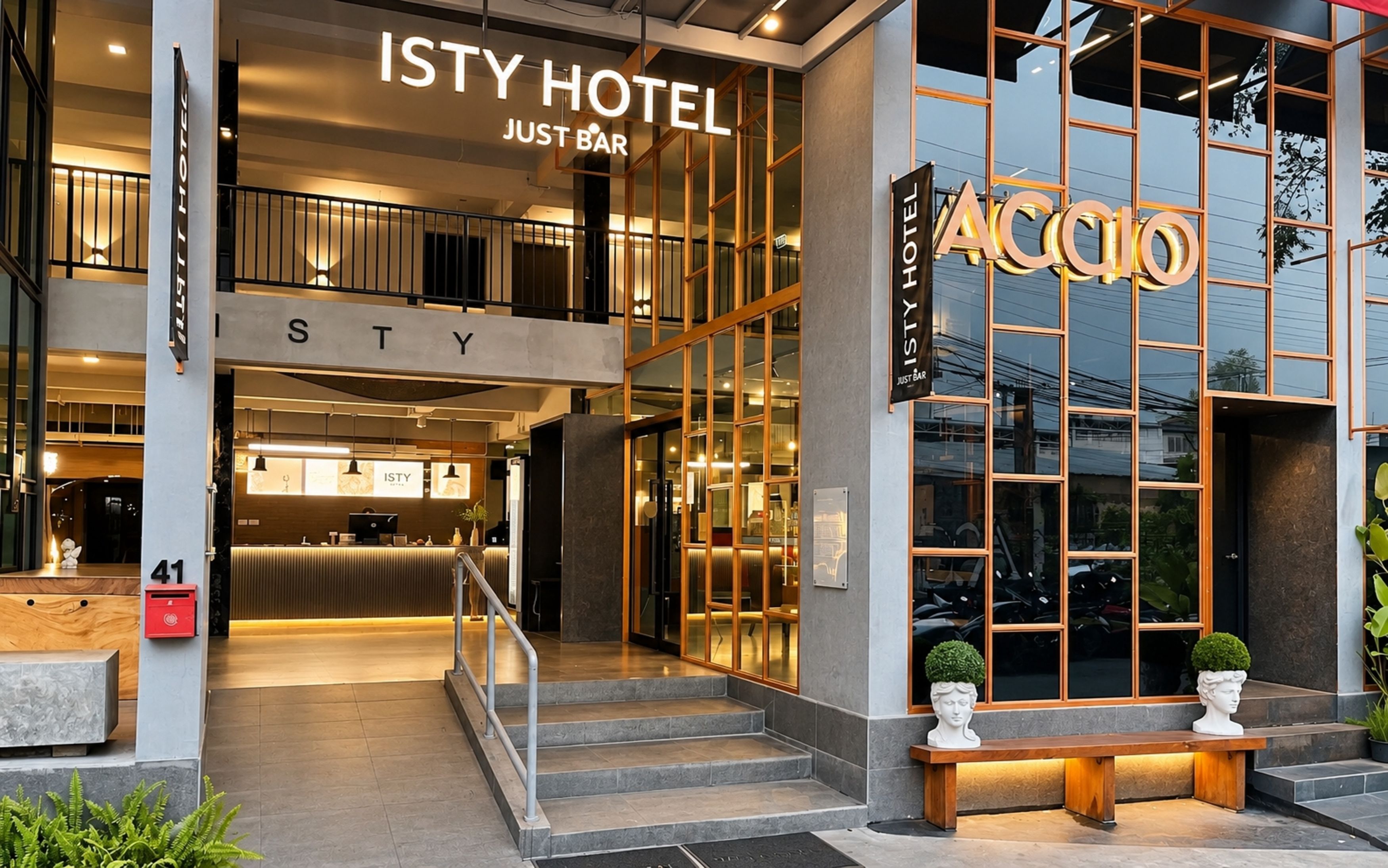 The exterior of ISTY HOTEL with a visible reception area and a staircase leading to the entrance.