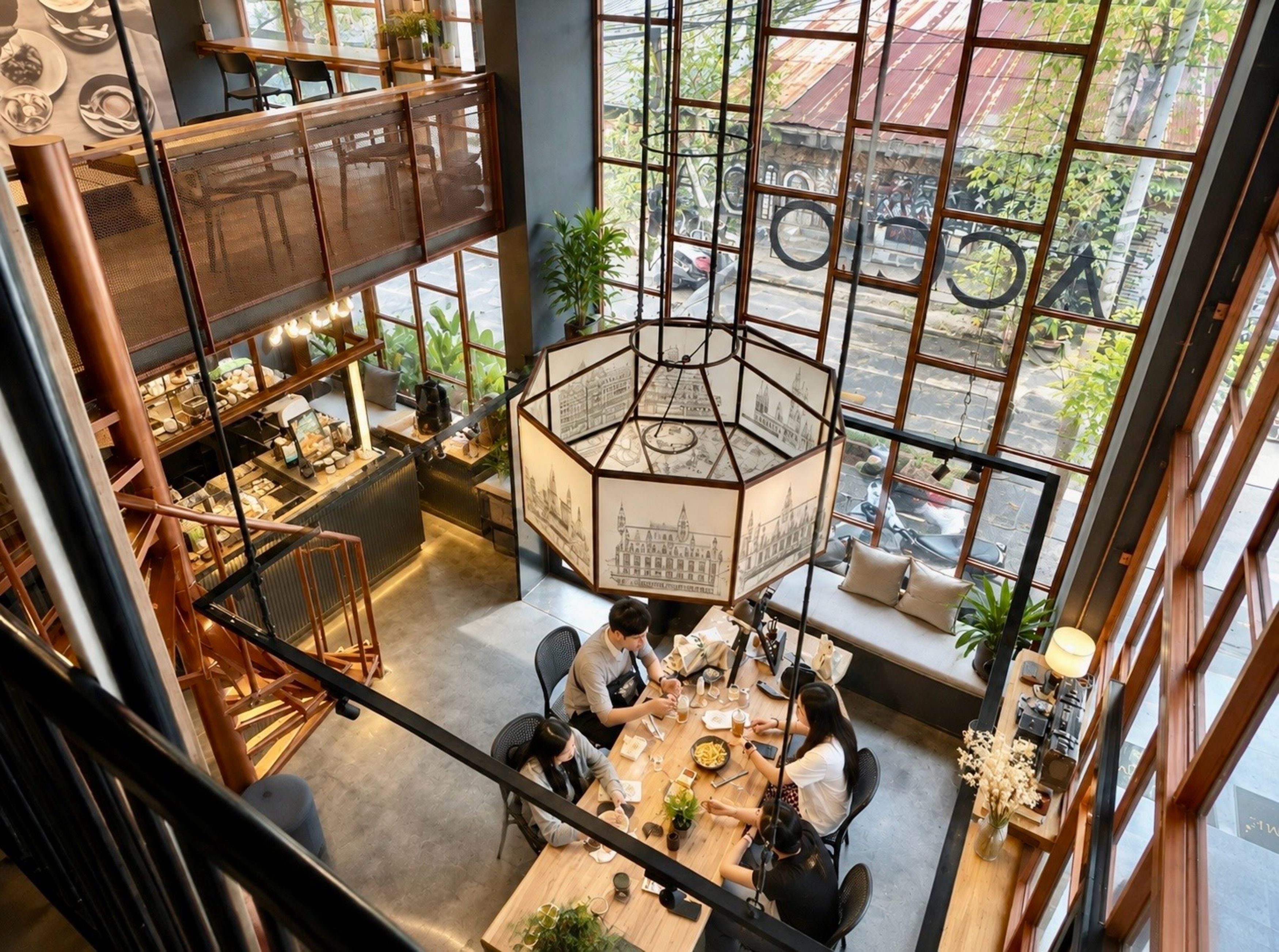 A restaurant with a high ceiling, large windows, and a central hanging light fixture.