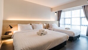 A hotel room with two beds, a bedside table with a lamp, and a large window with curtains. - ISTY Hotel (Chiang Mai)