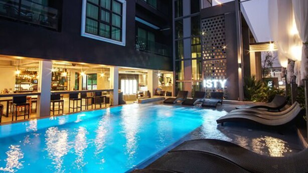 A pool area with lounge chairs and a bar. - ISTY Hotel (Chiang Mai)