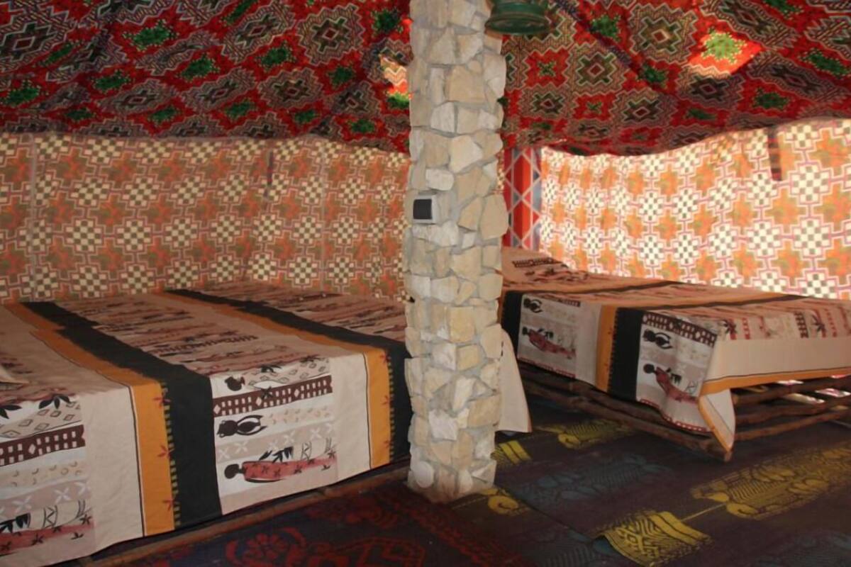 A room with patterned carpets, stone pillars, and traditional decor.