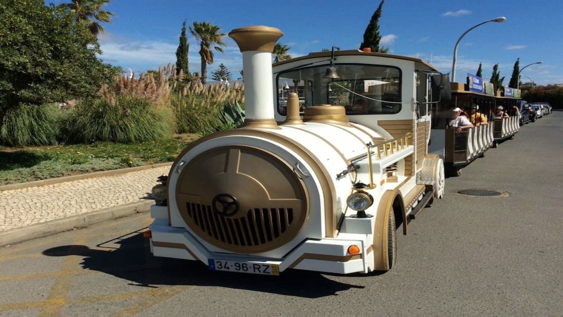 A vintage train with a classic design, featuring a prominent front engine and a series of passenger cars.