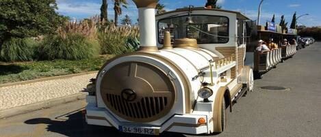 A vintage train with a classic design, featuring a prominent front engine and a series of passenger cars.