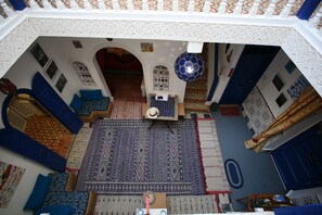 An interior view of a room with a patterned carpet, blue furniture, and decorative elements.