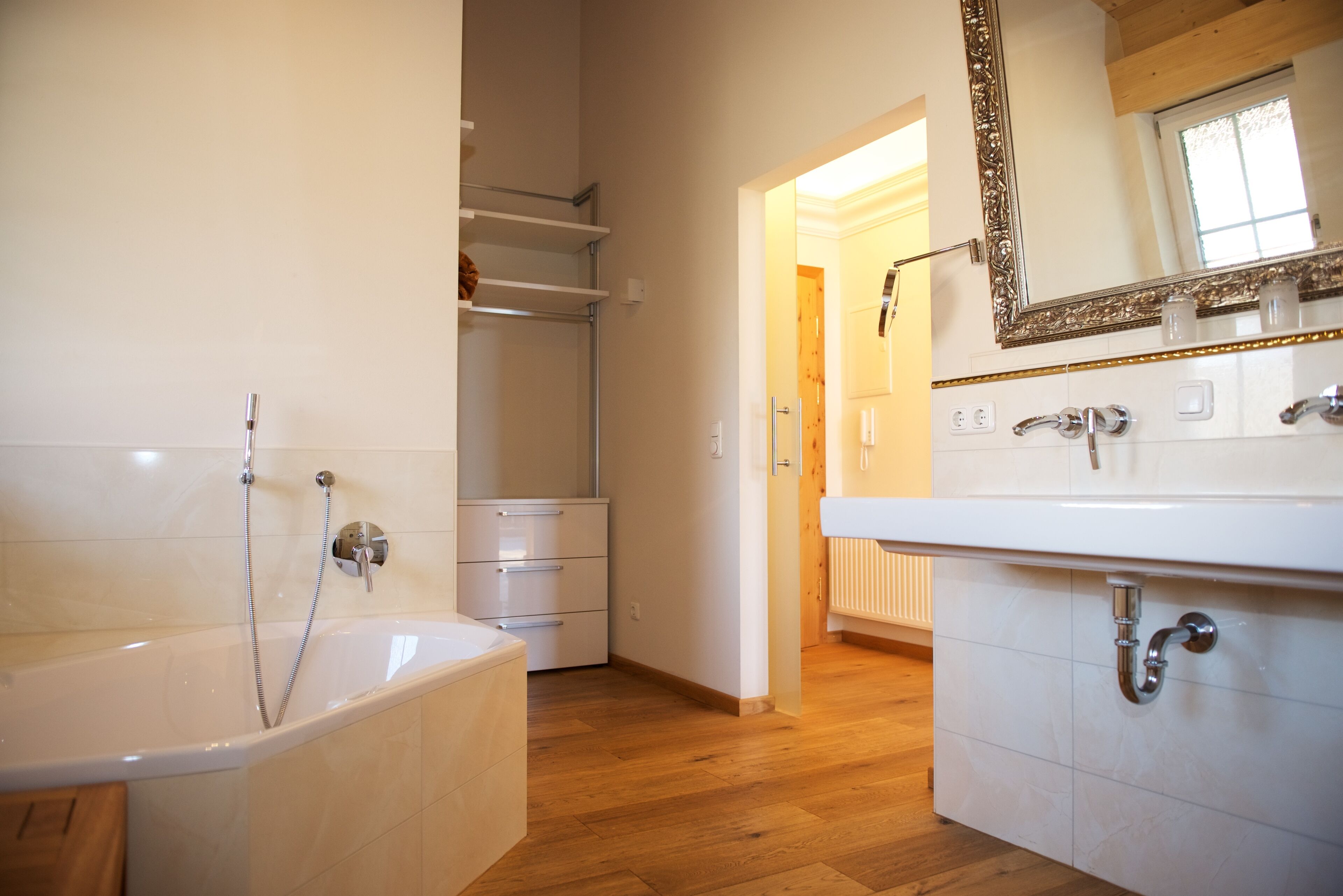A modern bathroom with a bathtub, a sink, and a mirror.