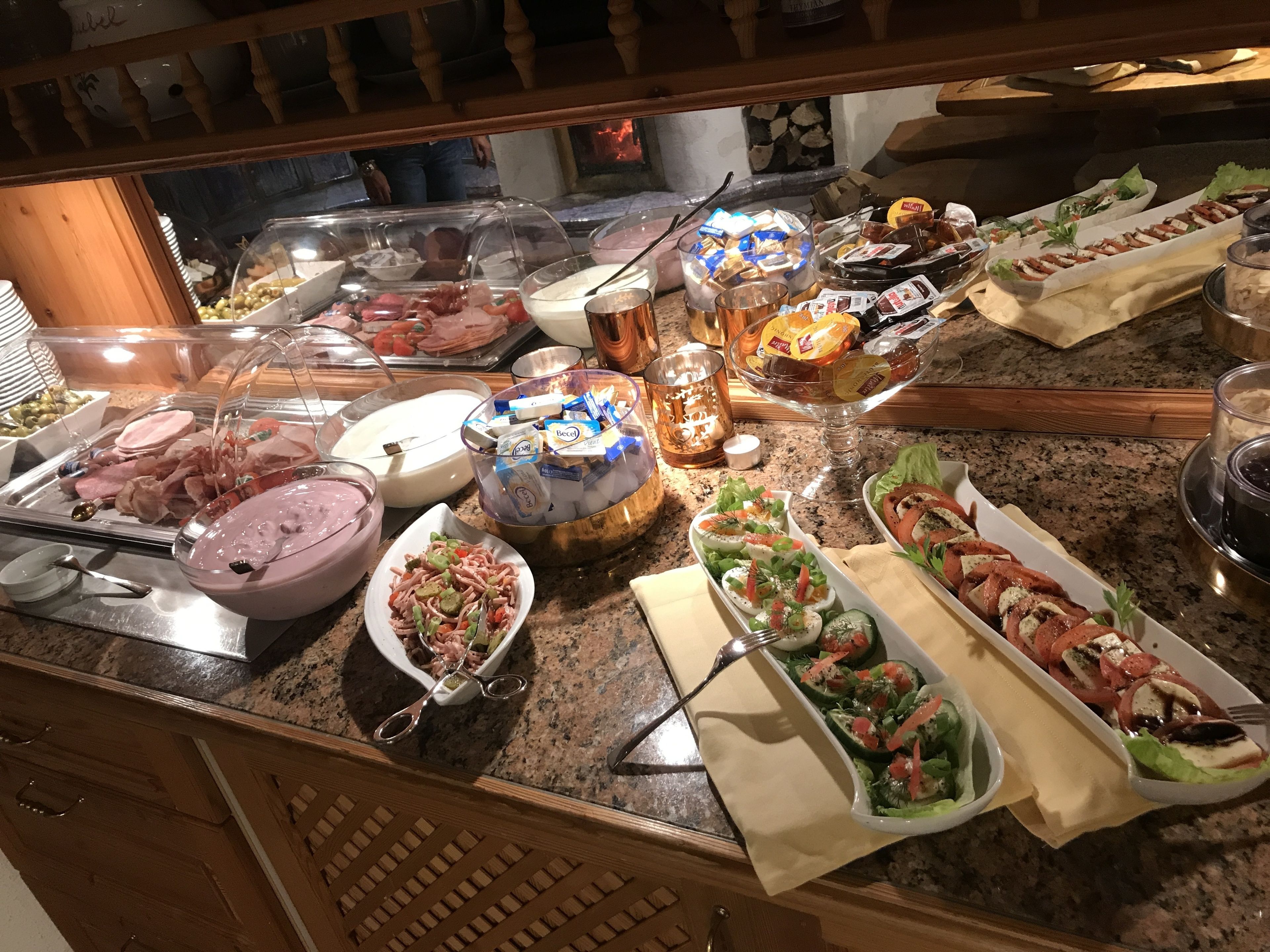 A buffet with various food items including salads, meats, and desserts.