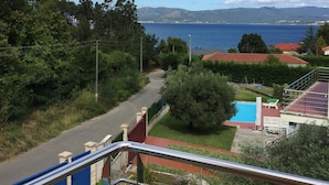 Zona residencial con carretera, piscina y vistas al mar y las montañas.