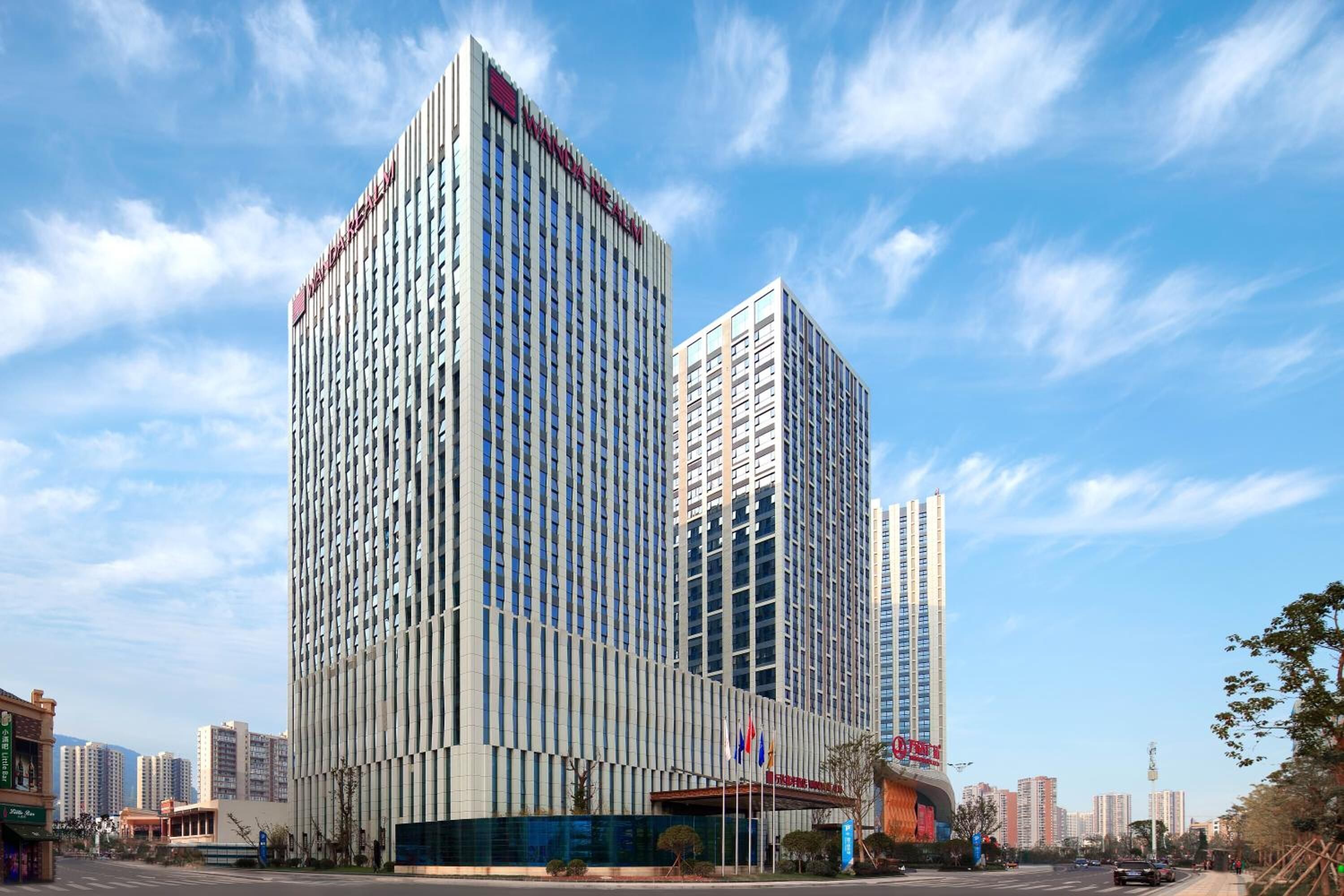 A modern hotel with a prominent vertical design, multiple floors, and a clear view of the surrounding urban environment.