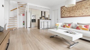 A modern living room with a white sofa, a coffee table, and a painting on the wall. - Smart Cuzco Castellana Penthouse (Madrid)