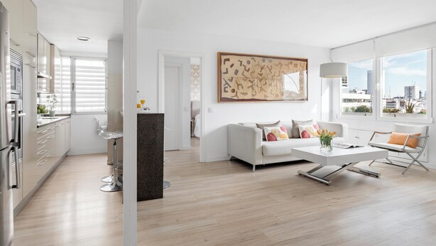 A modern apartment with a kitchen, living area, and large windows offering city views. - Smart Cuzco Castellana Penthouse (Madrid)