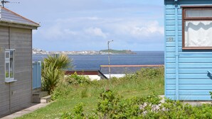 A coastal property with a view of the sea, a small building with a window, and a blue structure with a number 'C22' on it.