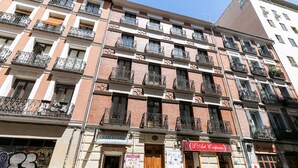 Um edifício com vários andares, varandas, um restaurante no térreo chamado "Cham Kebab" e um café chamado "Art & Crepe".