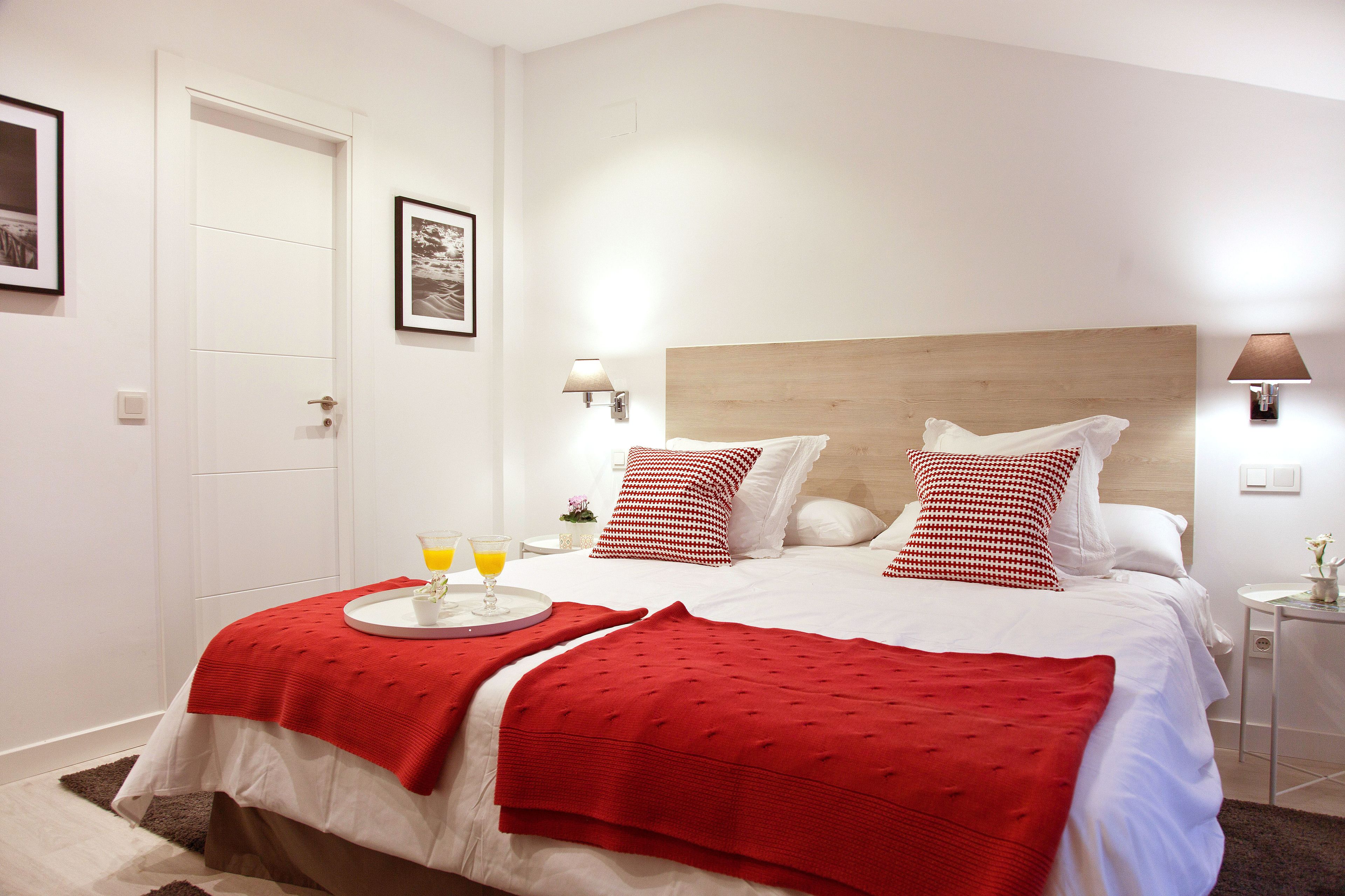 Een netjes ingerichte hotelkamer met een bed, nachtkastjes en een deur.