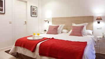 Een netjes ingerichte hotelkamer met een bed, nachtkastjes en een deur.