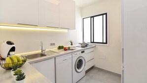Eine moderne Küche mit Einbauwaschmaschine, Spüle und Fenster.