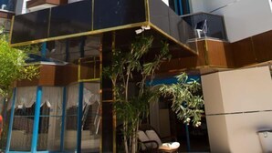 A multi-story residential building with balconies, a glass entrance, and outdoor seating. - Sea Bird Hotel (Didim)