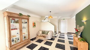 A spacious living area with a wooden cabinet, a sofa, a coffee table, and a staircase.