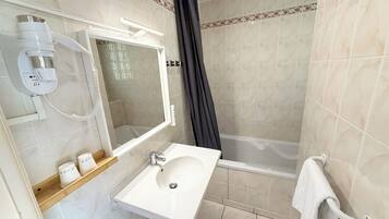 A bathroom with a white sink, mirror, and shower curtain.