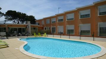 Een seizoensgebonden buitenzwembad en parasols bij het zwembad