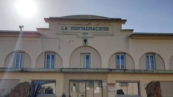 Un bâtiment portant l’enseigne « LA MONTAGNACOISE 1937 » et une entrée de café.