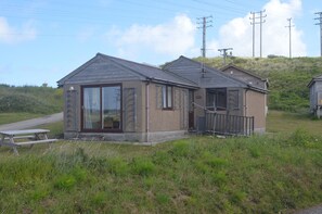 Un petit bâtiment d’un seul étage, doté d’un toit en pente, d’une entrée principale avec une porte et d’un petit espace porche.