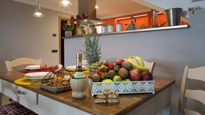 Una encimera de cocina con un frutero, una botella y una cesta de galletas.