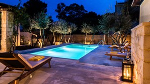 A swimming pool with lounge chairs and a wooden deck. - Koukounari luxury villa with pool. A timeless paradise!  (Chania)