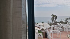 A view of a resort with white outdoor seating and a pool area, overlooking a body of water. - La Corvetta (Monopoli)