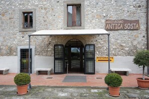 Een stenen gebouw met een bord waarop staat 'Agriturismo Antica Sosta'.