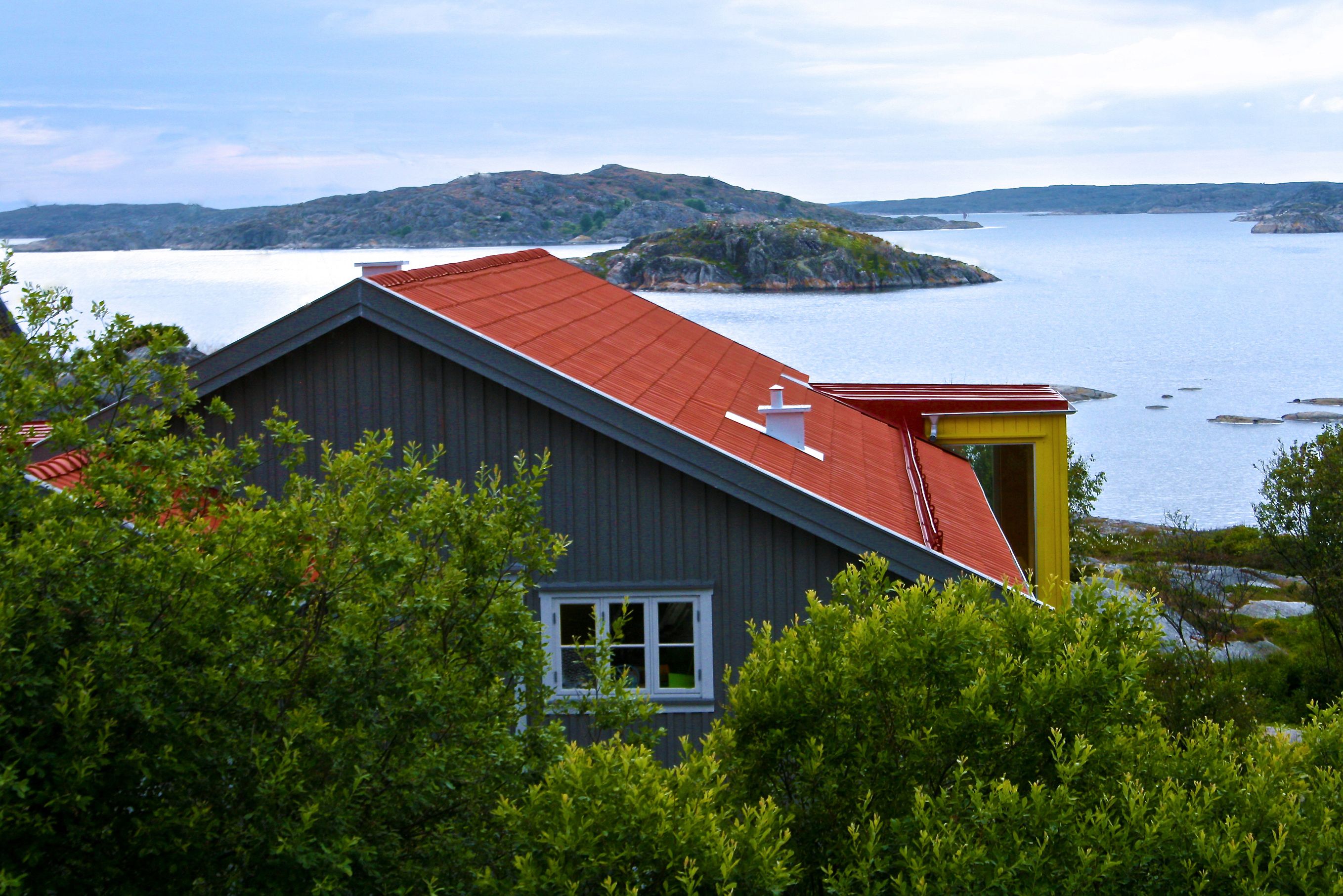 A house with a red roof, a chimney, and a window.
