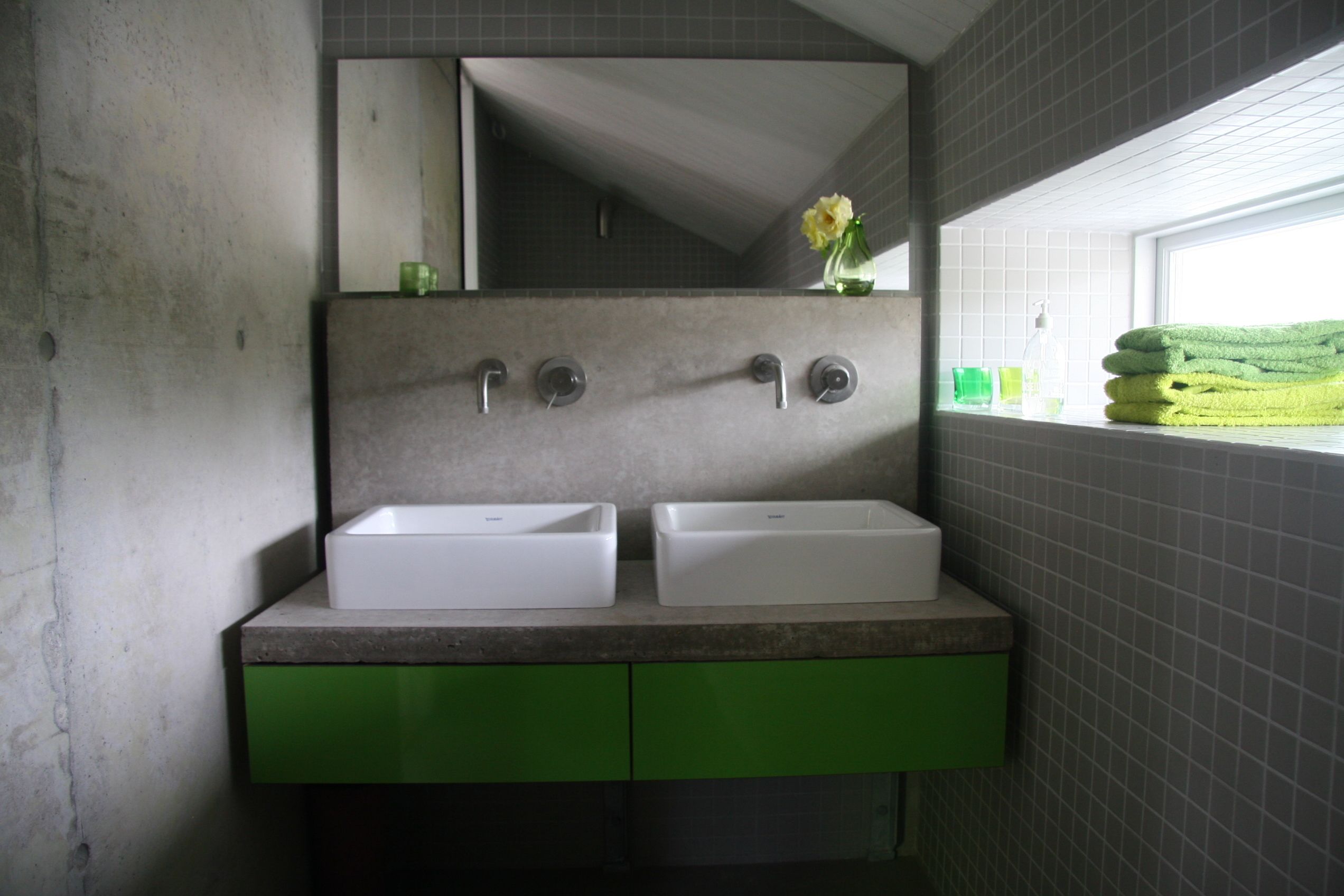 A bathroom with two sinks, a mirror, and a window.
