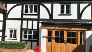 A traditional half-timbered house with a wooden front door, white walls, and a tiled roof. - Lovely 1 bedroom, with parking & patio, 5 min walk from Lexicon  & Train Station (Bracknell)